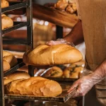cropped-shot-of-shop-assistant-arranging-loafs-of-bread-in-supermarket cropped-shot-of-shop-assistant-arranging-loafs-of-bread-in-supermarket